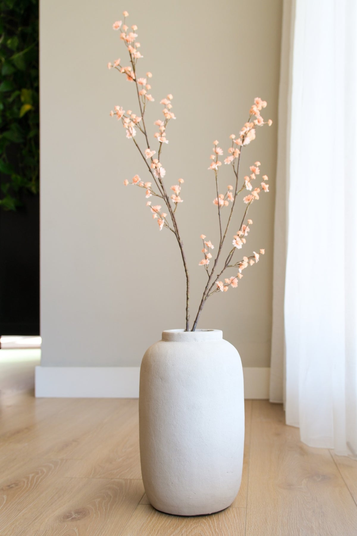 Beige flesvaas met decoratieve droogtakken