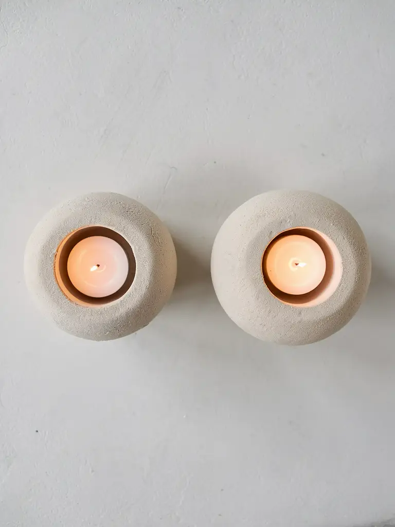 Bovenaanzicht van twee beige aardewerk waxinelichthouders op voet met waxinelichtje – STILL