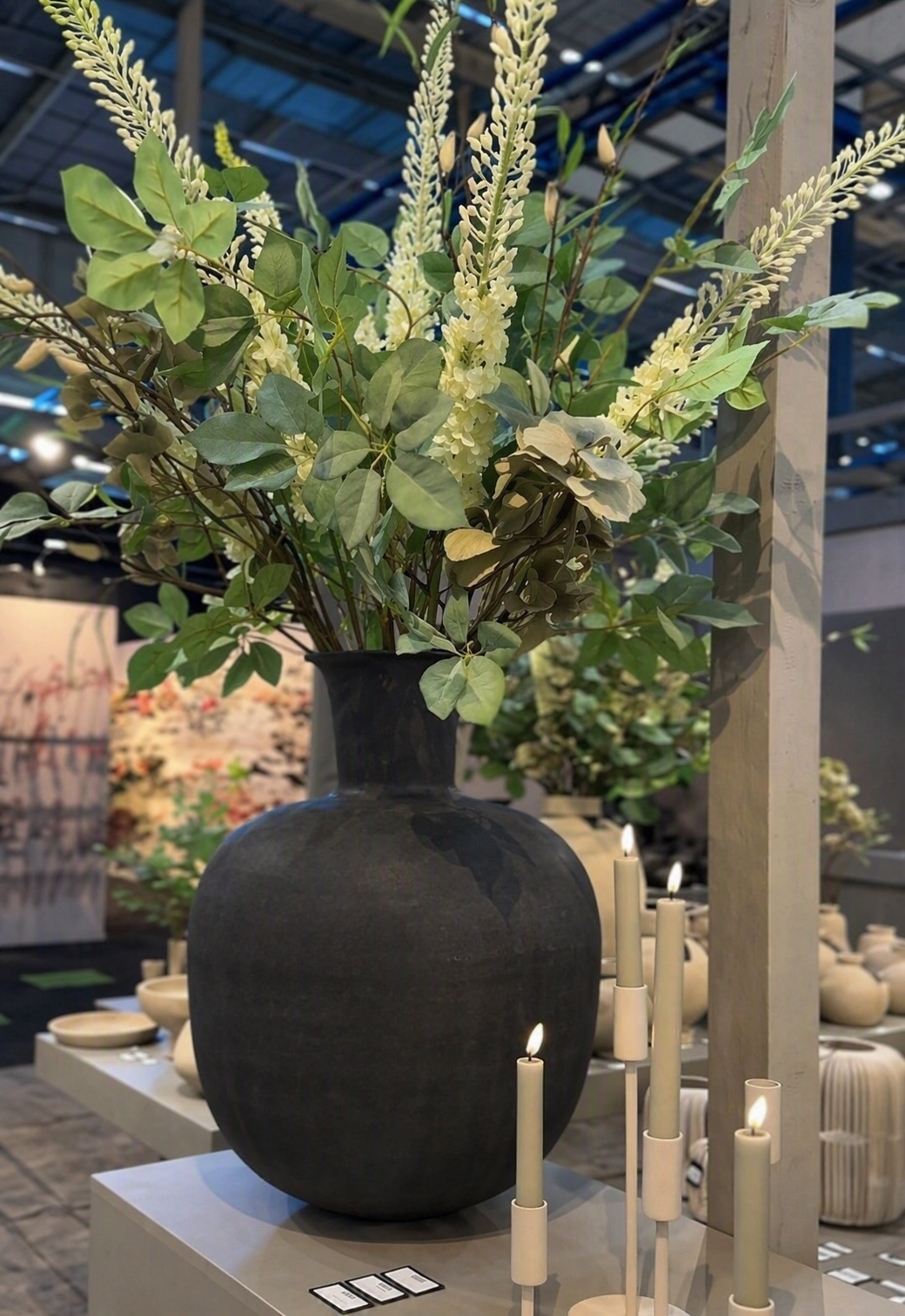 Grote zwarte design vaas van 60 cm met bloemen in modern interieur